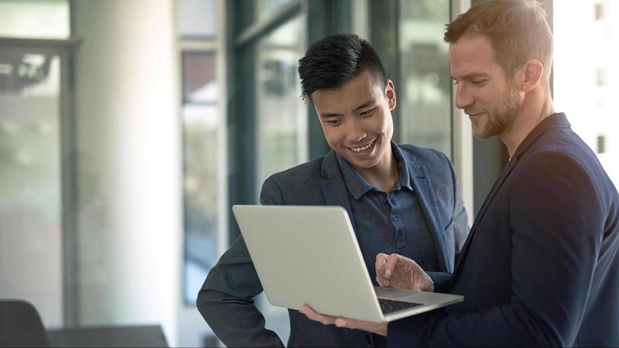 IT professional showing businessman technical details on his computer.