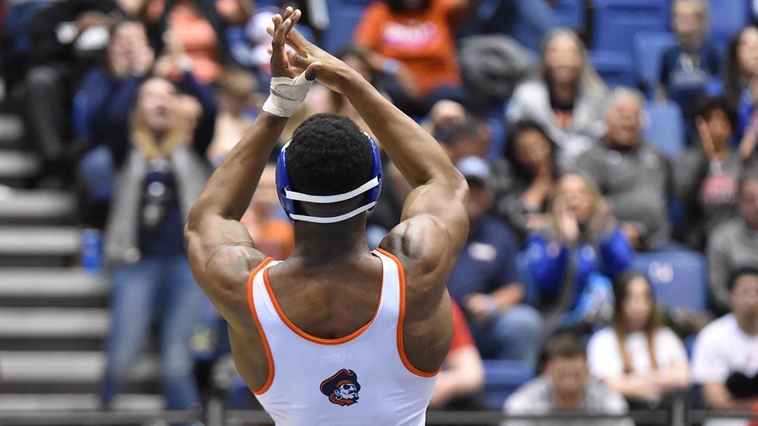 Marauders wrestling athlete clapping in front of crowd at a wrestling competition.