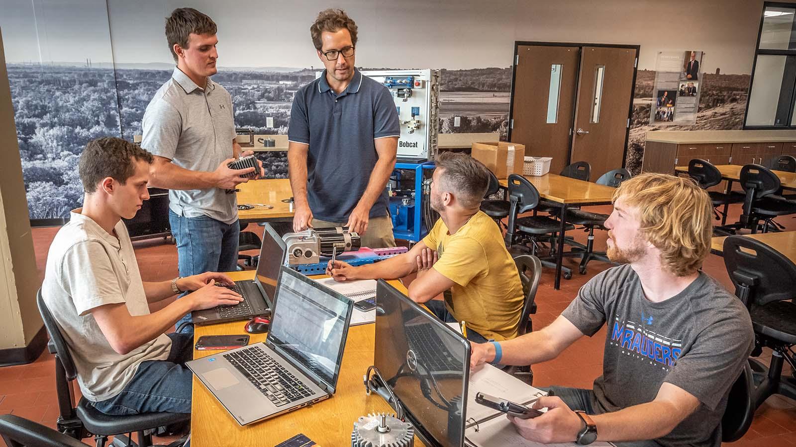 Engineering students meeting with professor in the new design center 