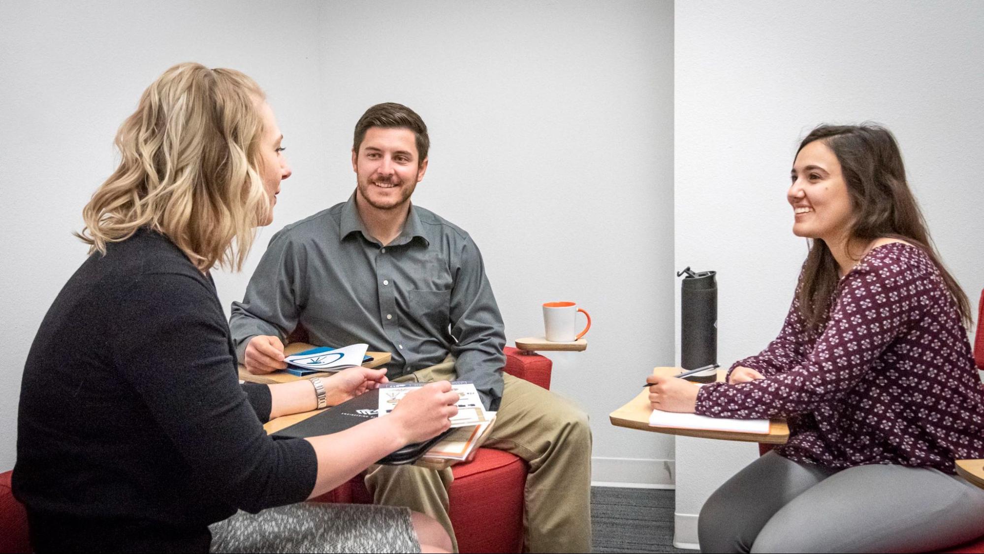 Businesswoman discussing marketing plans with two clients.