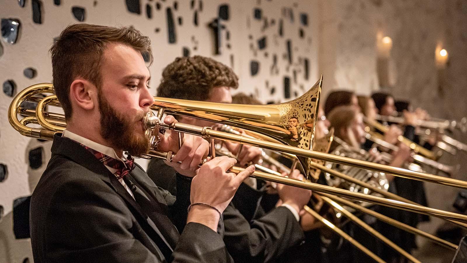 Brass section of concert band performing in formal attire
