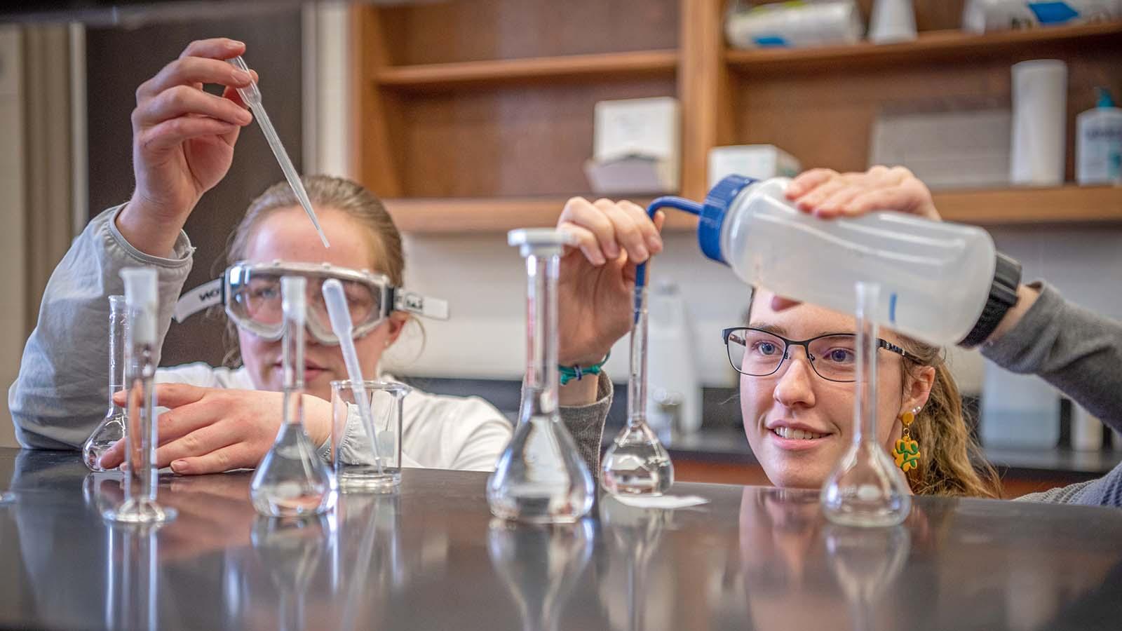 Two SURVE students adding solutions into beakers