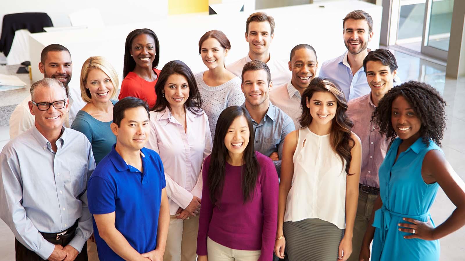 Portrait of multi-cultural office staff standing in lobby casually