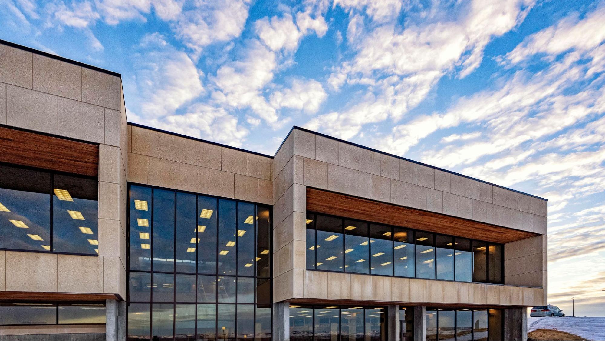 Exterior view of the Welder Library with vibrant clouds moving across the sky behind.