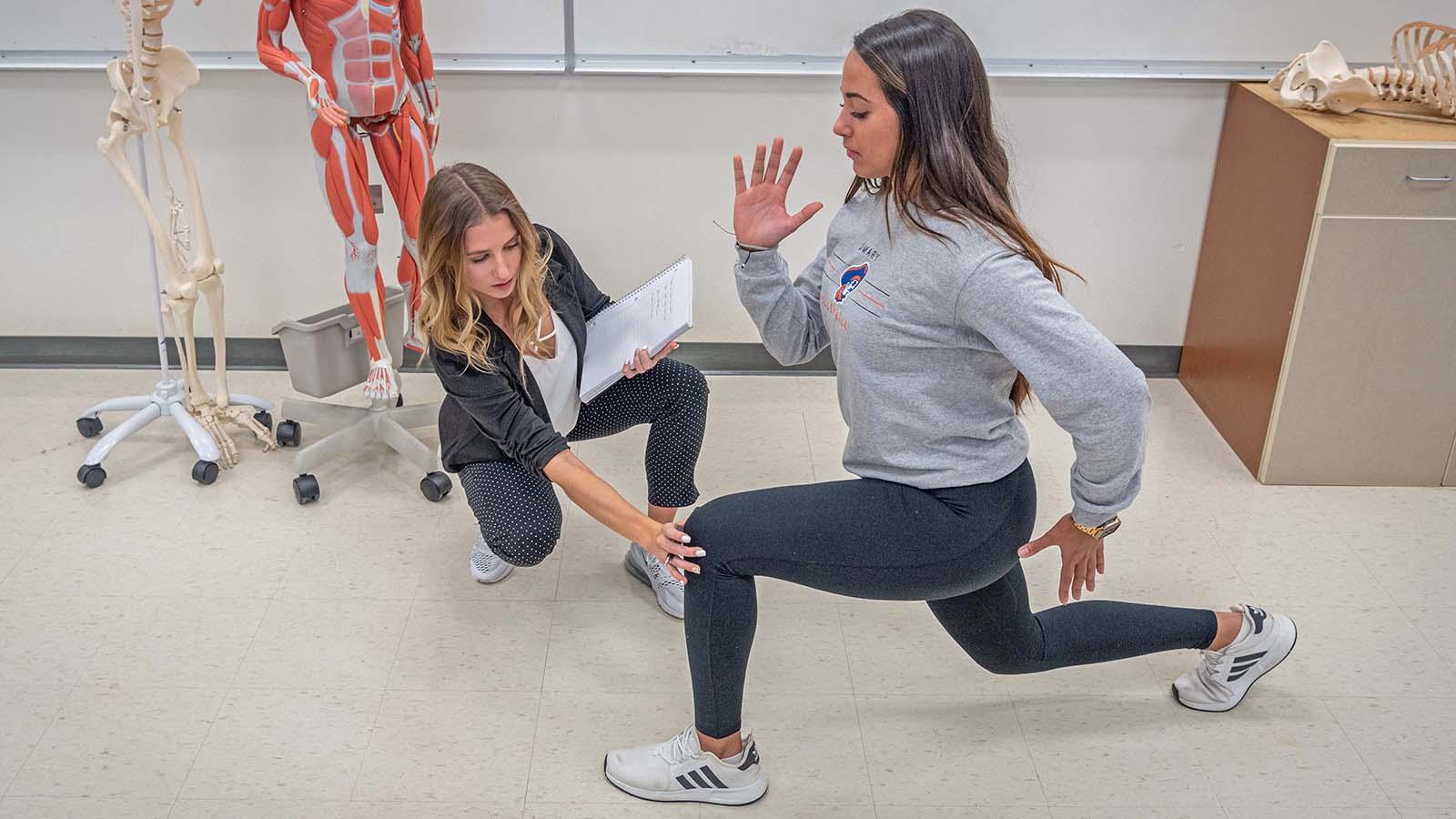 Wellness student assessing another student lunging 