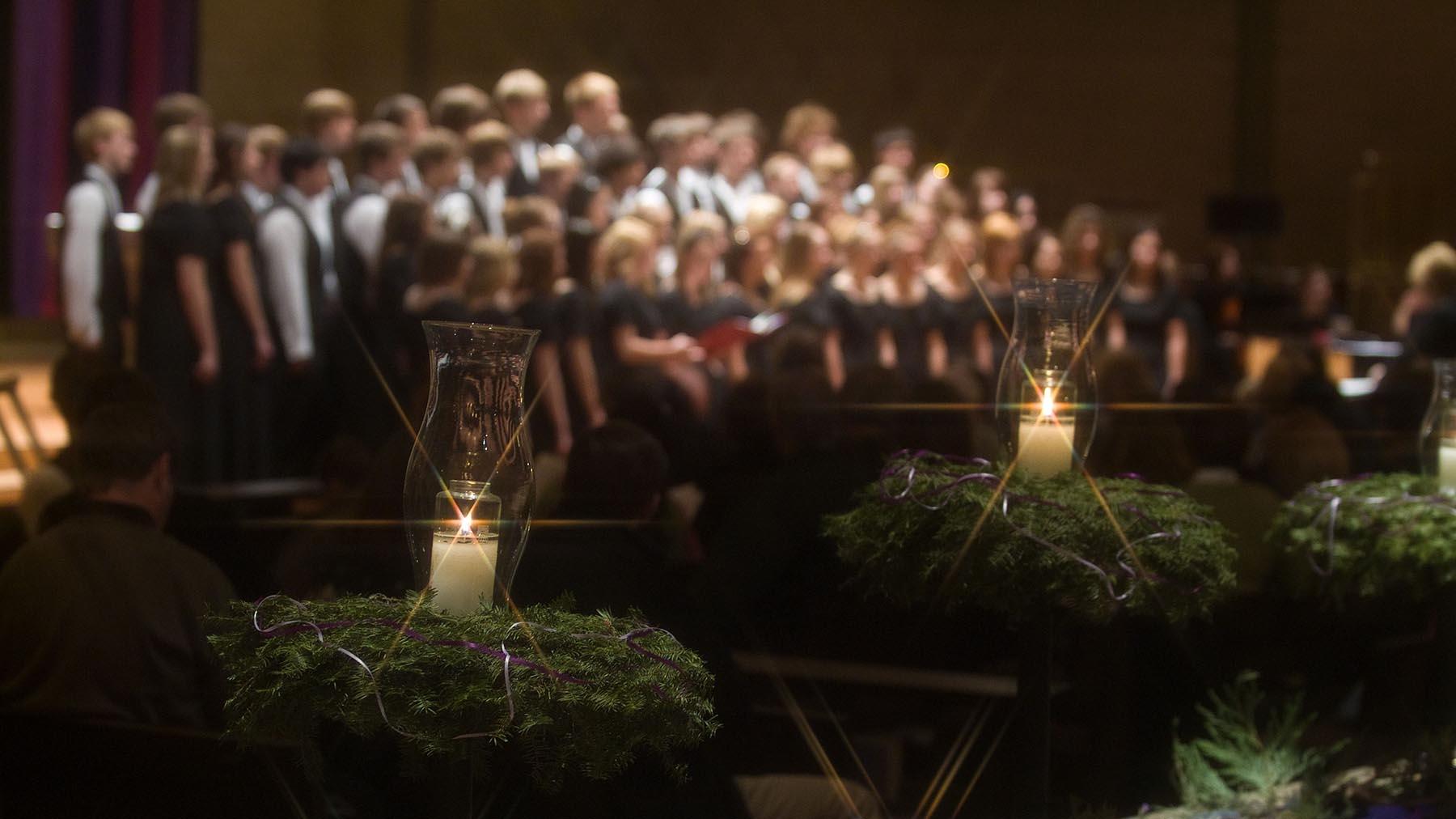 Candles and wreaths in forefront with choir singing in the background