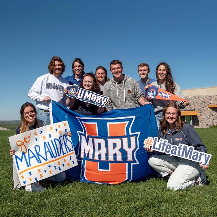 Group of students with signs and flags to show their support of Mary