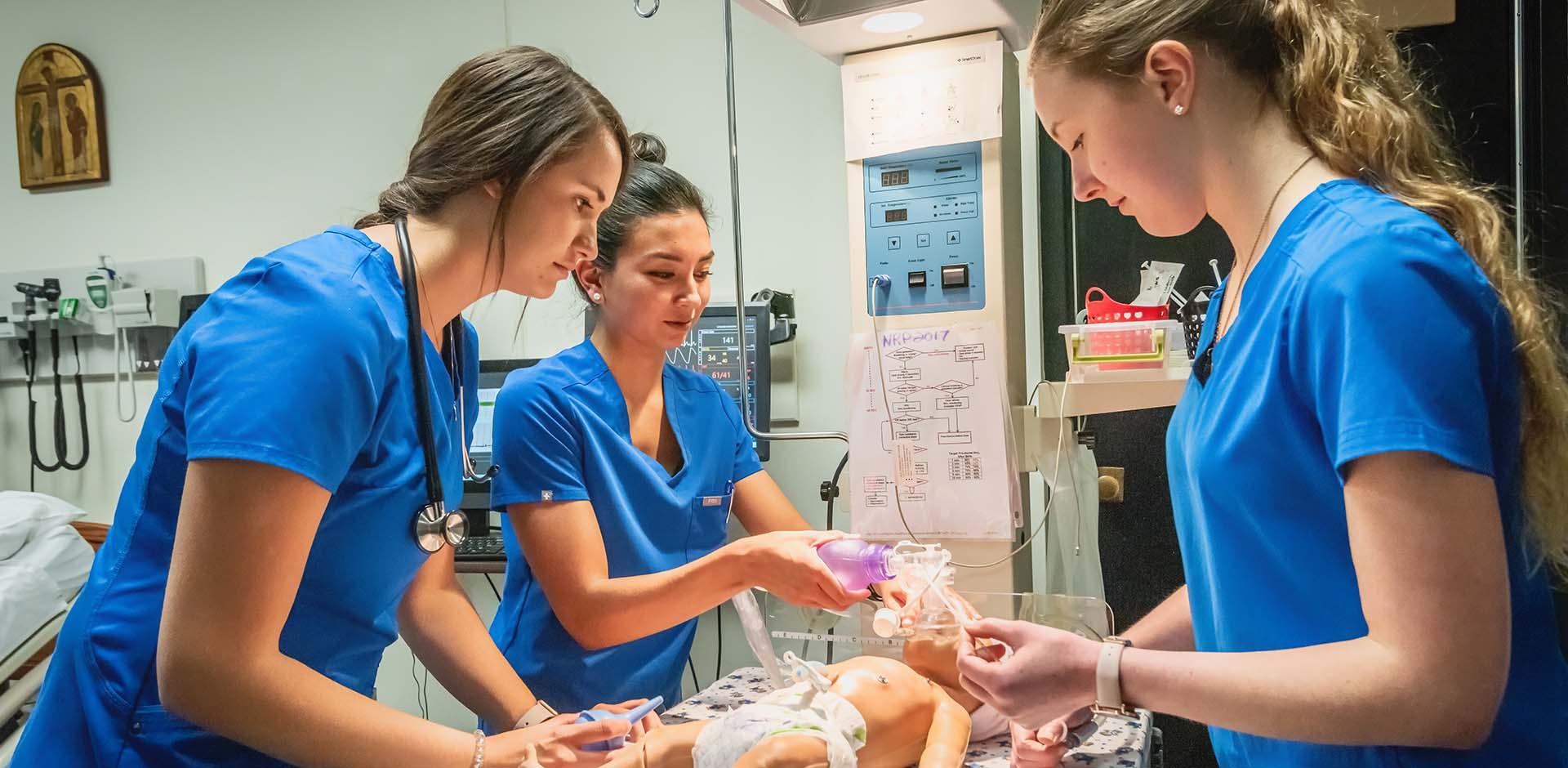 Nursing students practicing clinical skills on simulator