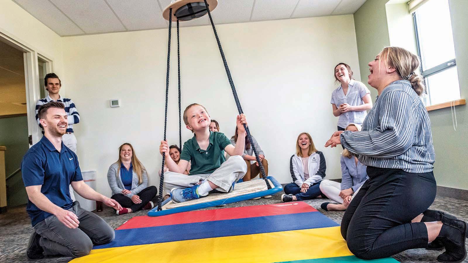 Smiling occupational therapy doctorate students working with child in the Billings clinic