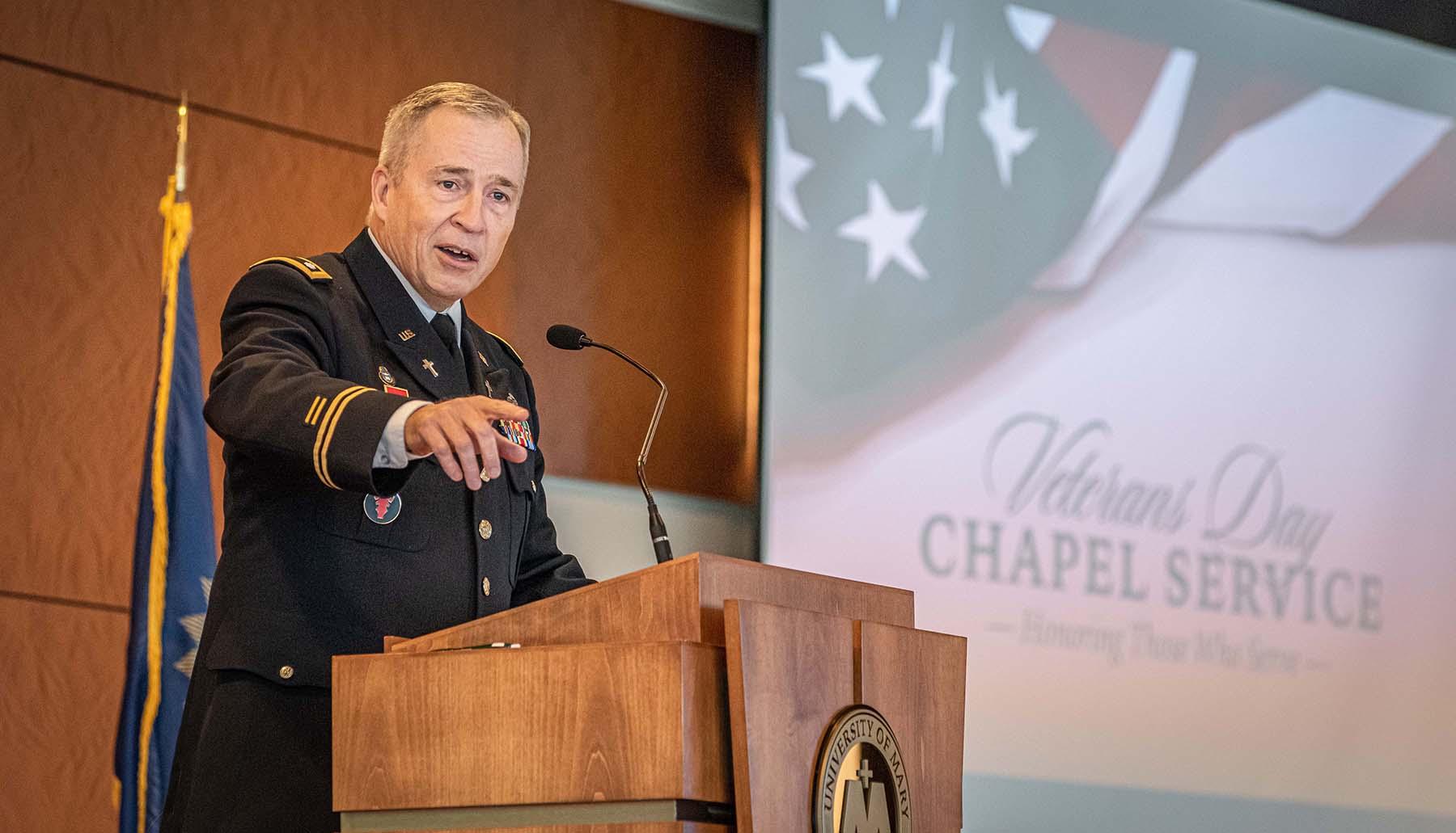 Man in uniform talking at a podium for Veterans Day.