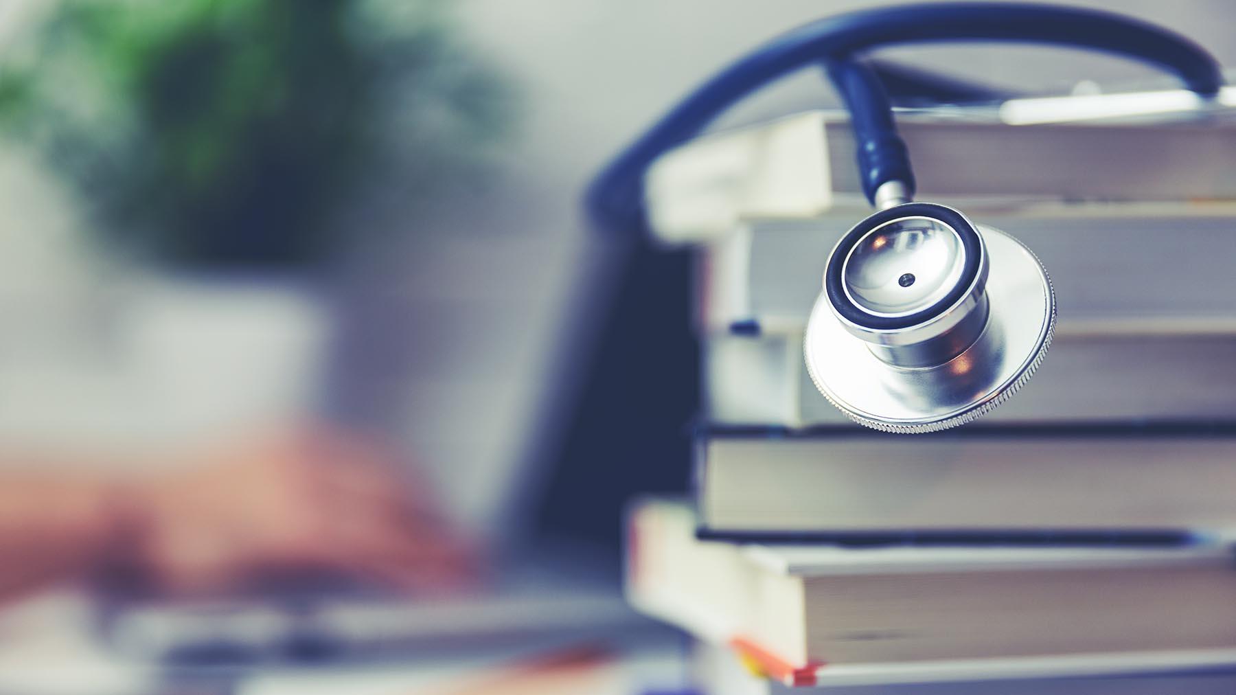A stethoscope on a stack of books