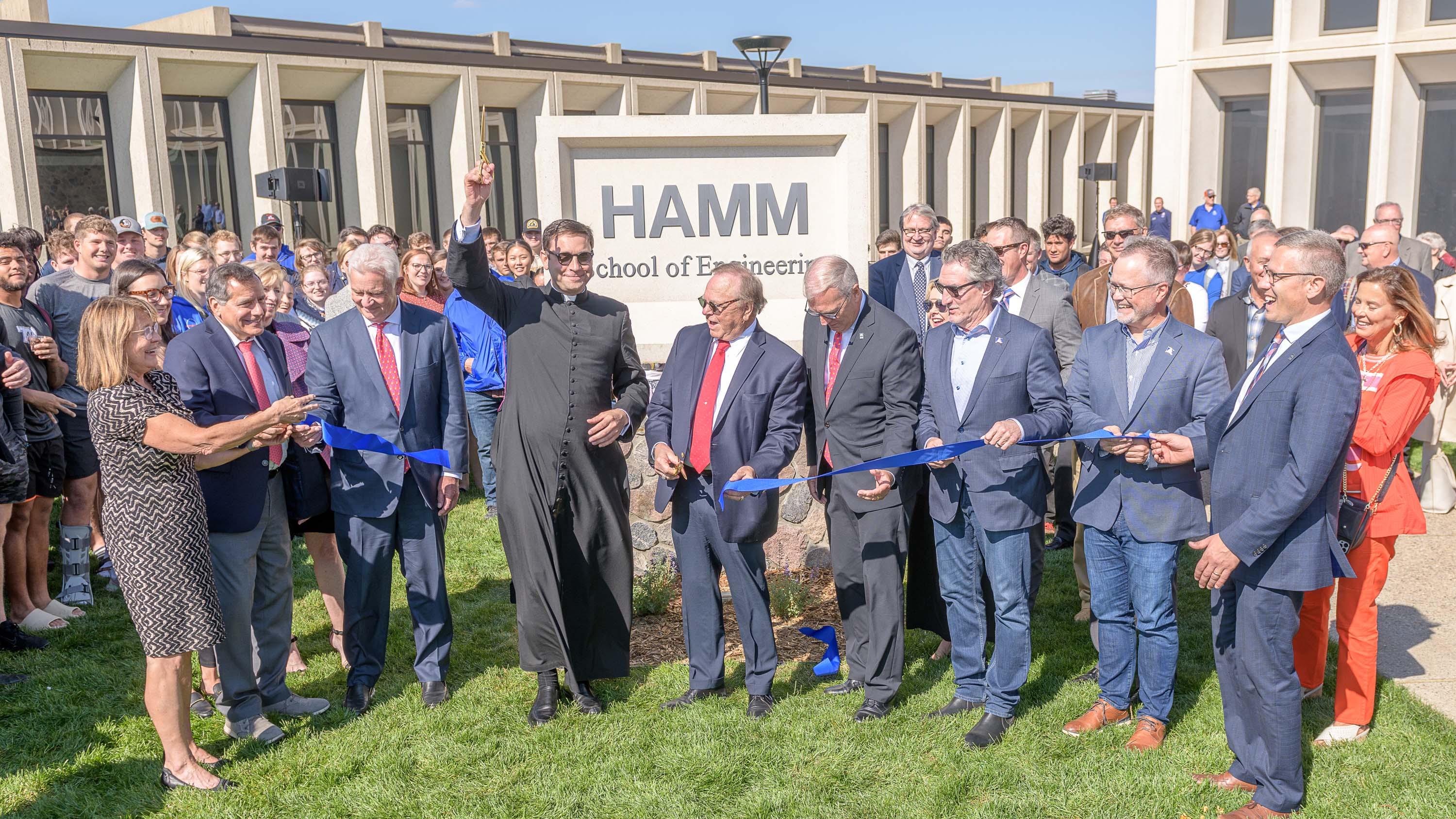 Monsignor Shea and Harold Hamm cutting the ribbon of the Hamm School of Engineering.