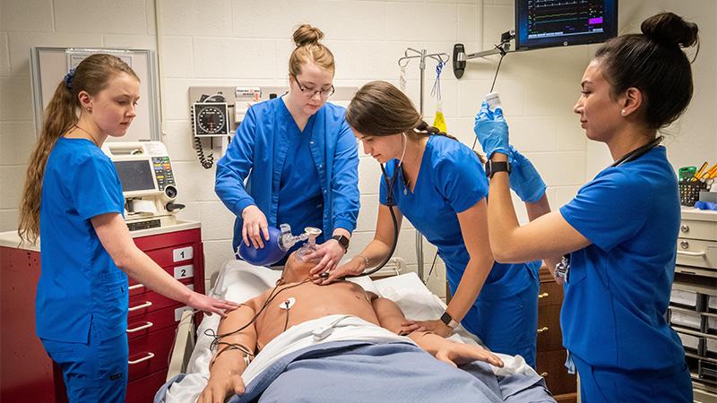 Nursing Students standing around medical human dummy