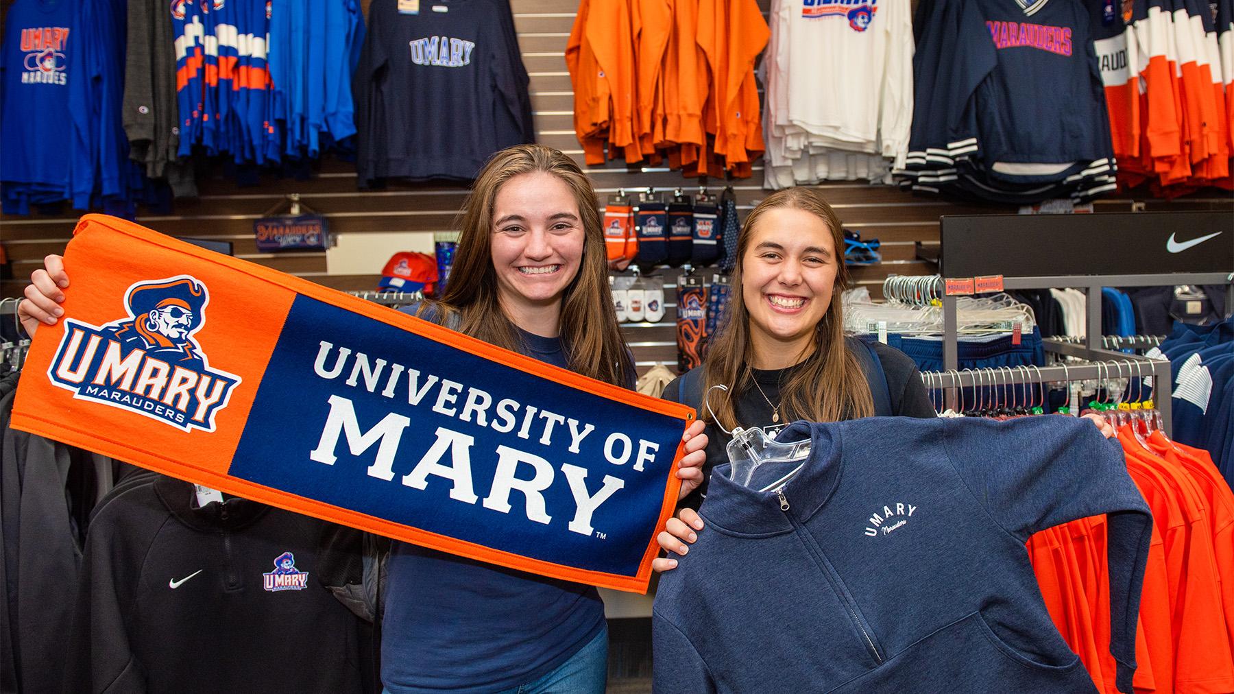 Students holding apparel in the bookstore