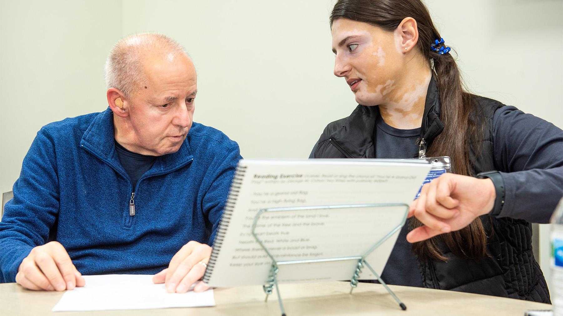 Student working at the Speech Language Pathology Clinic with an elderly patient.