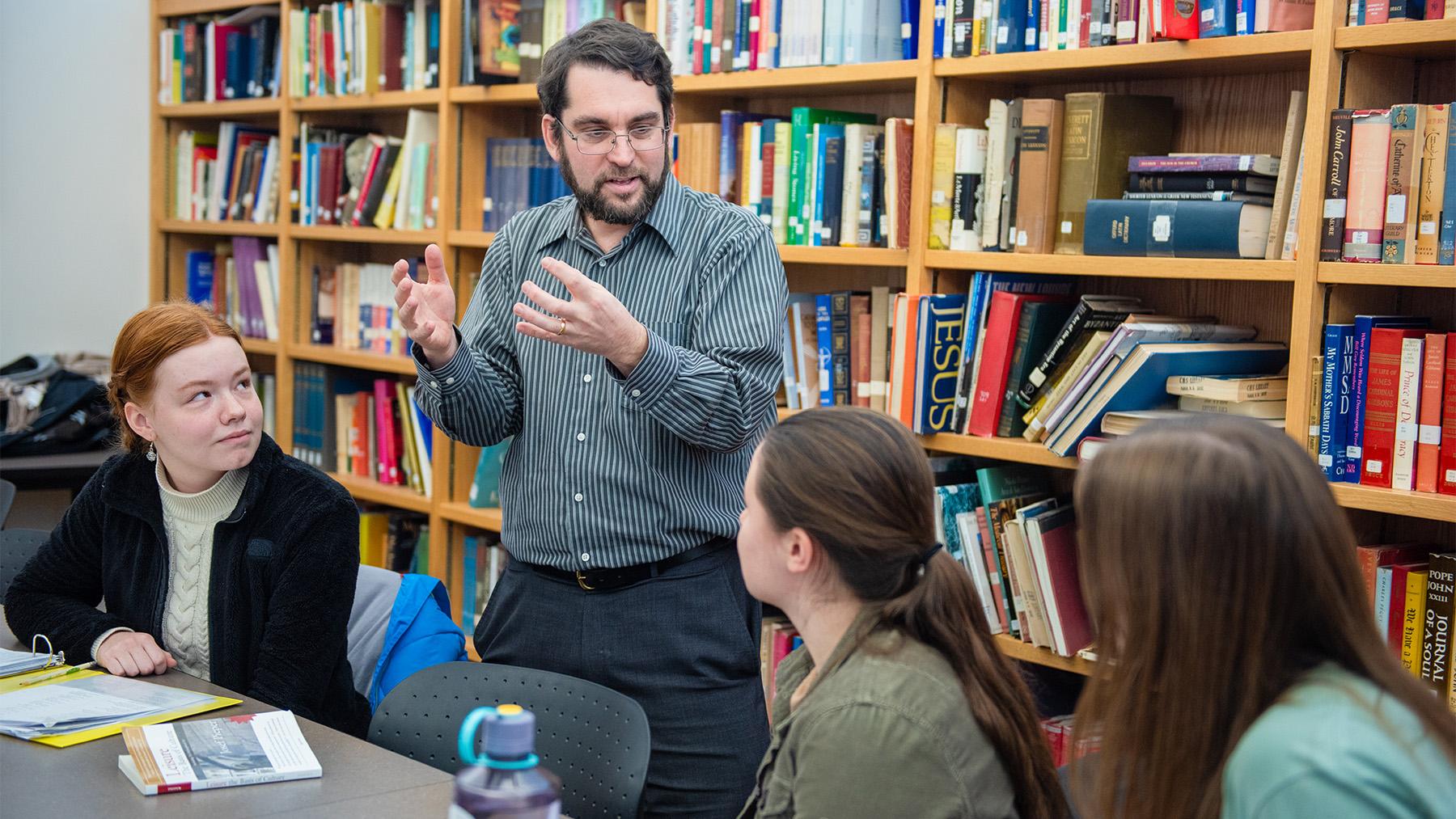 Joseph Stuart teaching a history class with his students listening attentively.