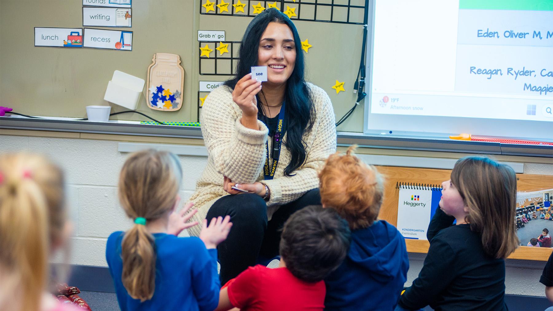 A female teachers teaching reading to a class of kindergartners