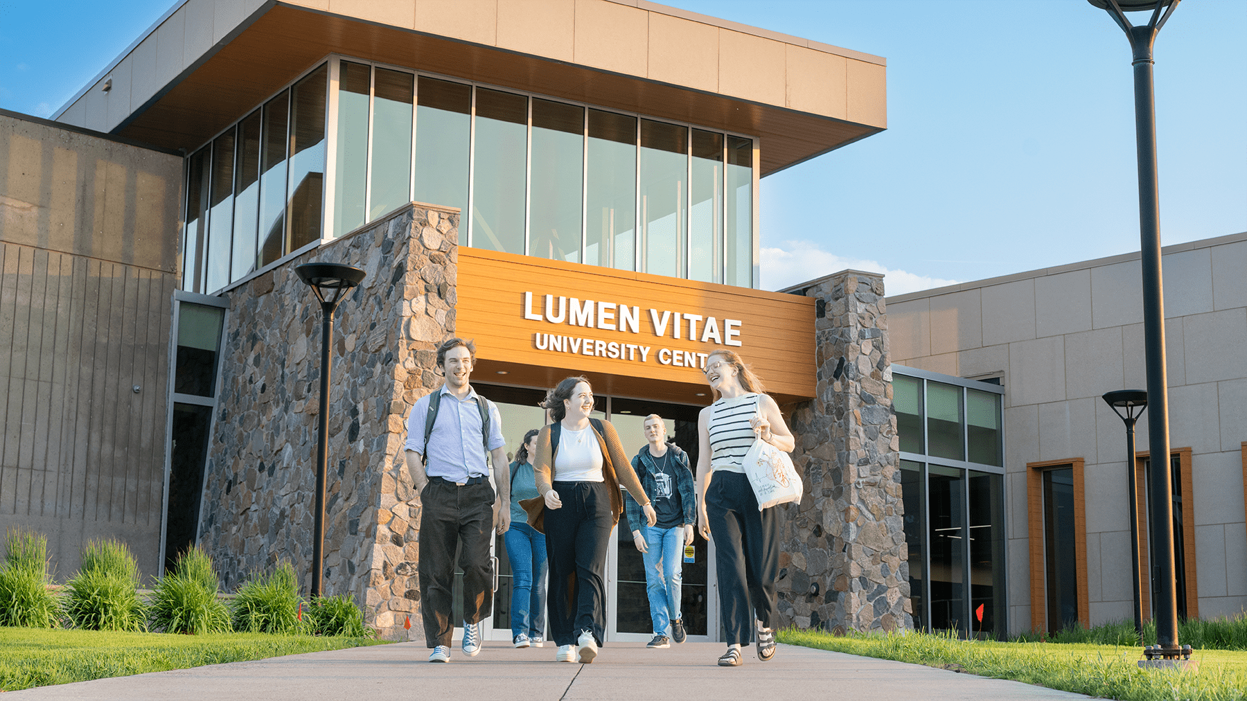 Students walking outside the lumen vitae center.