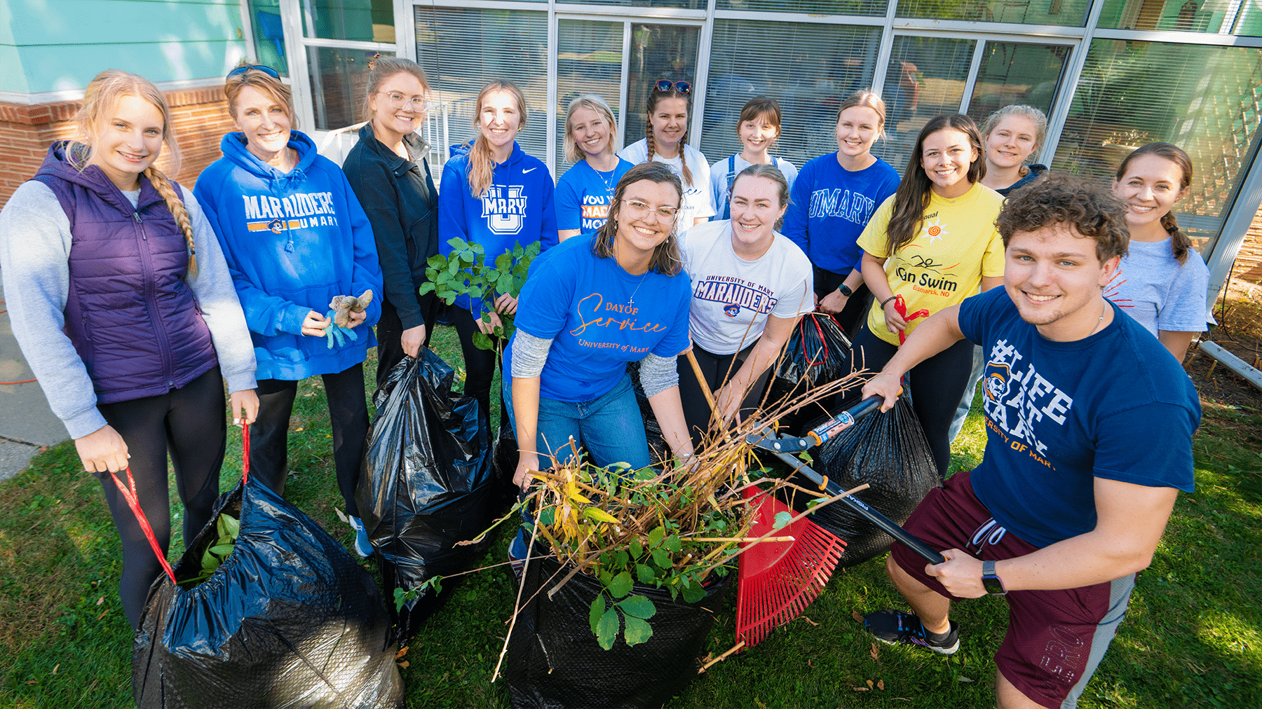 students cleaning up leaves during Day of Service.