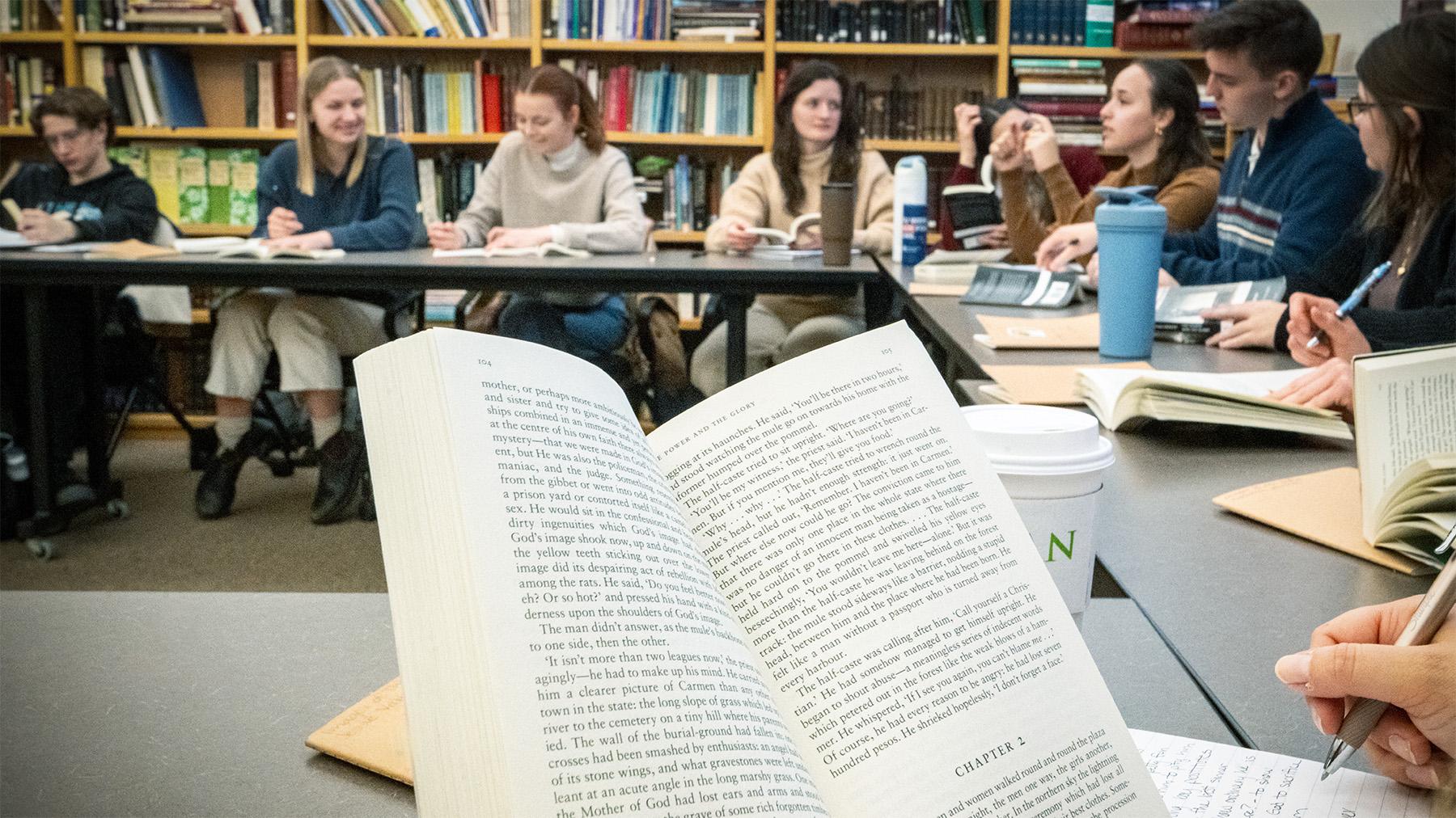 students reading an discussing a book in class