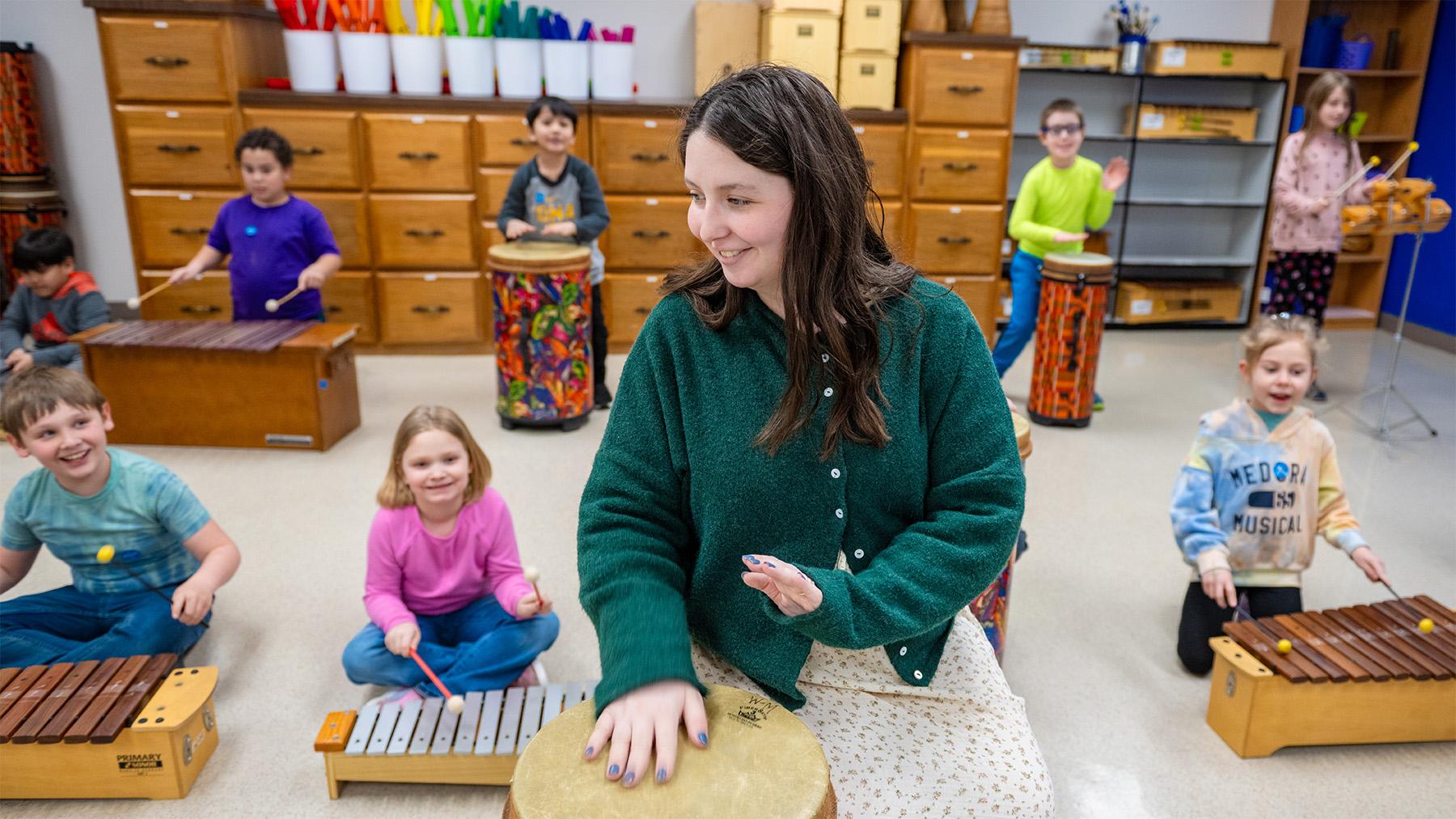 student teaching music to kids in a class room