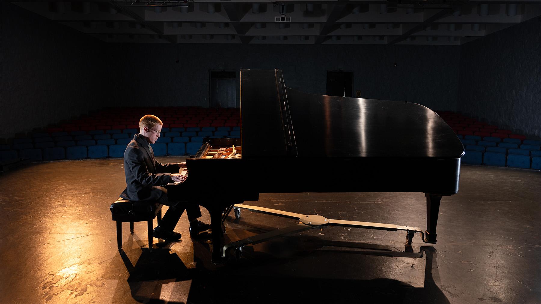 student playing the piano in a concert hall