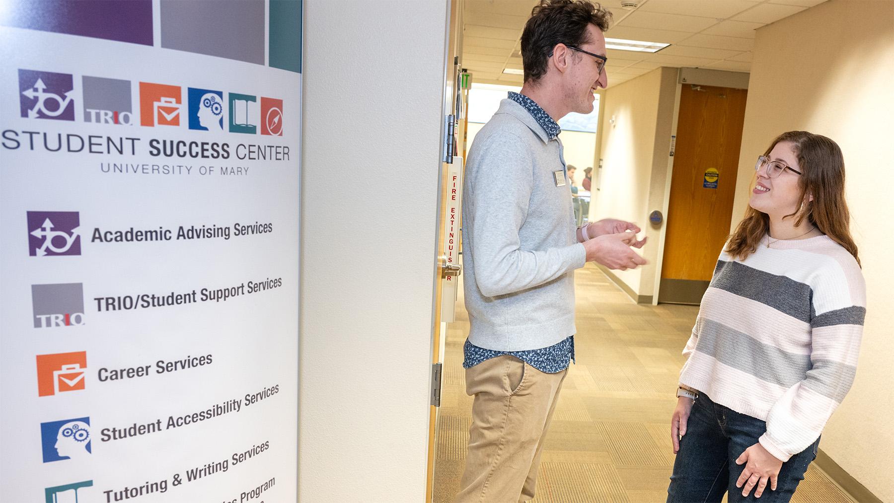 Advisor talking to a student in front of the Student Success Center
