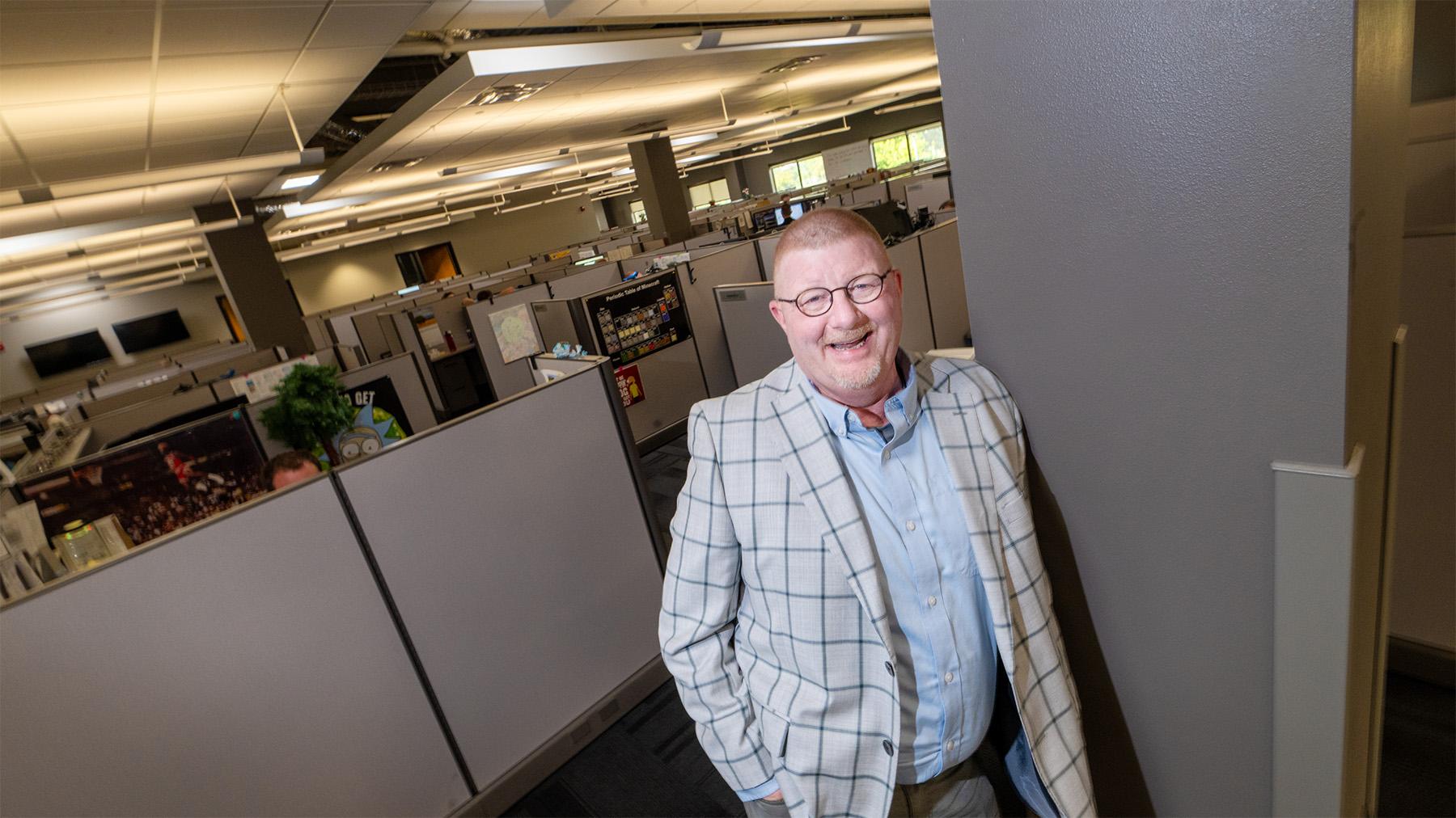 Doug standing in the NISC office cubicles.