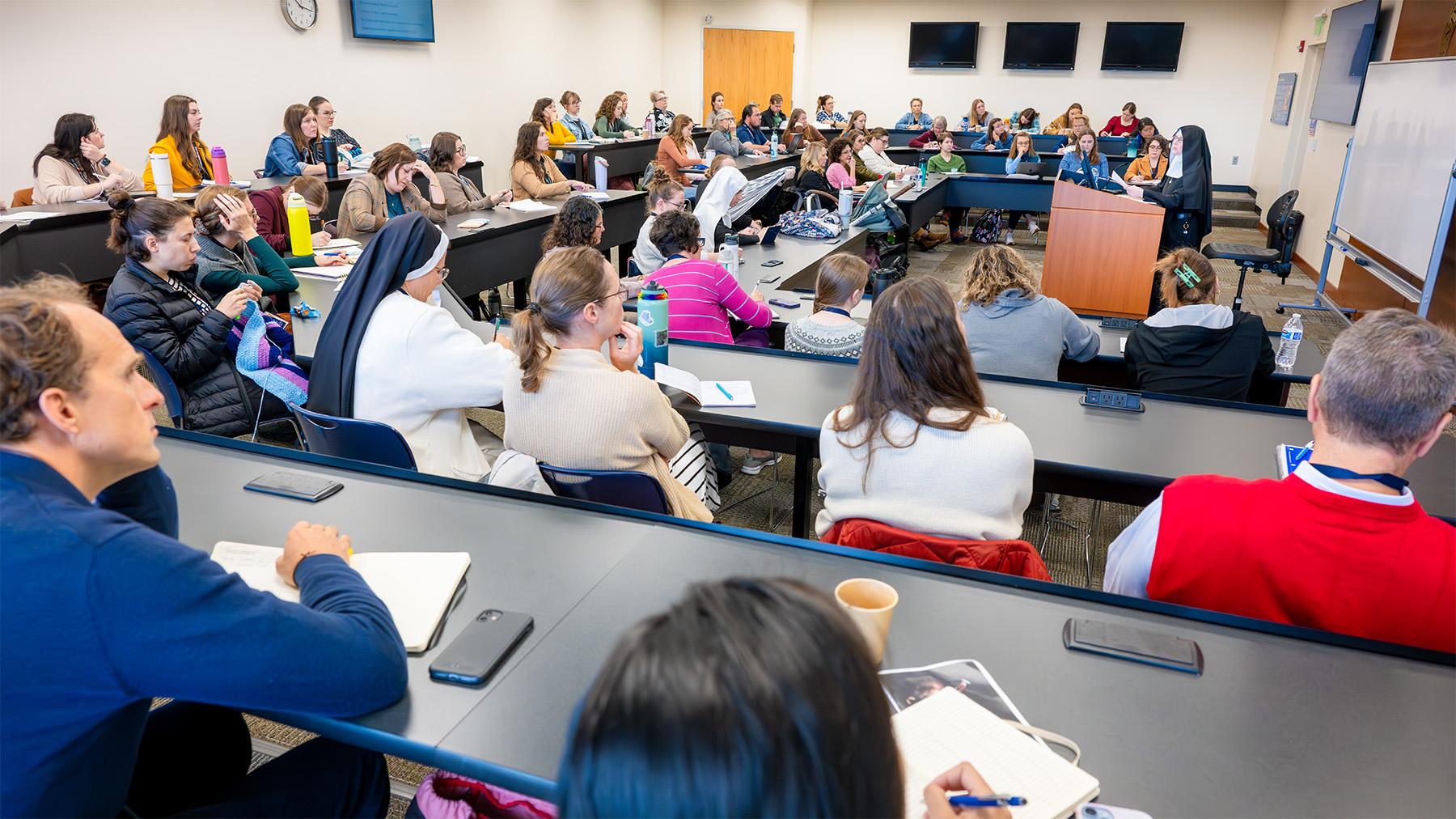 registrants listening to a lecture with a speaker