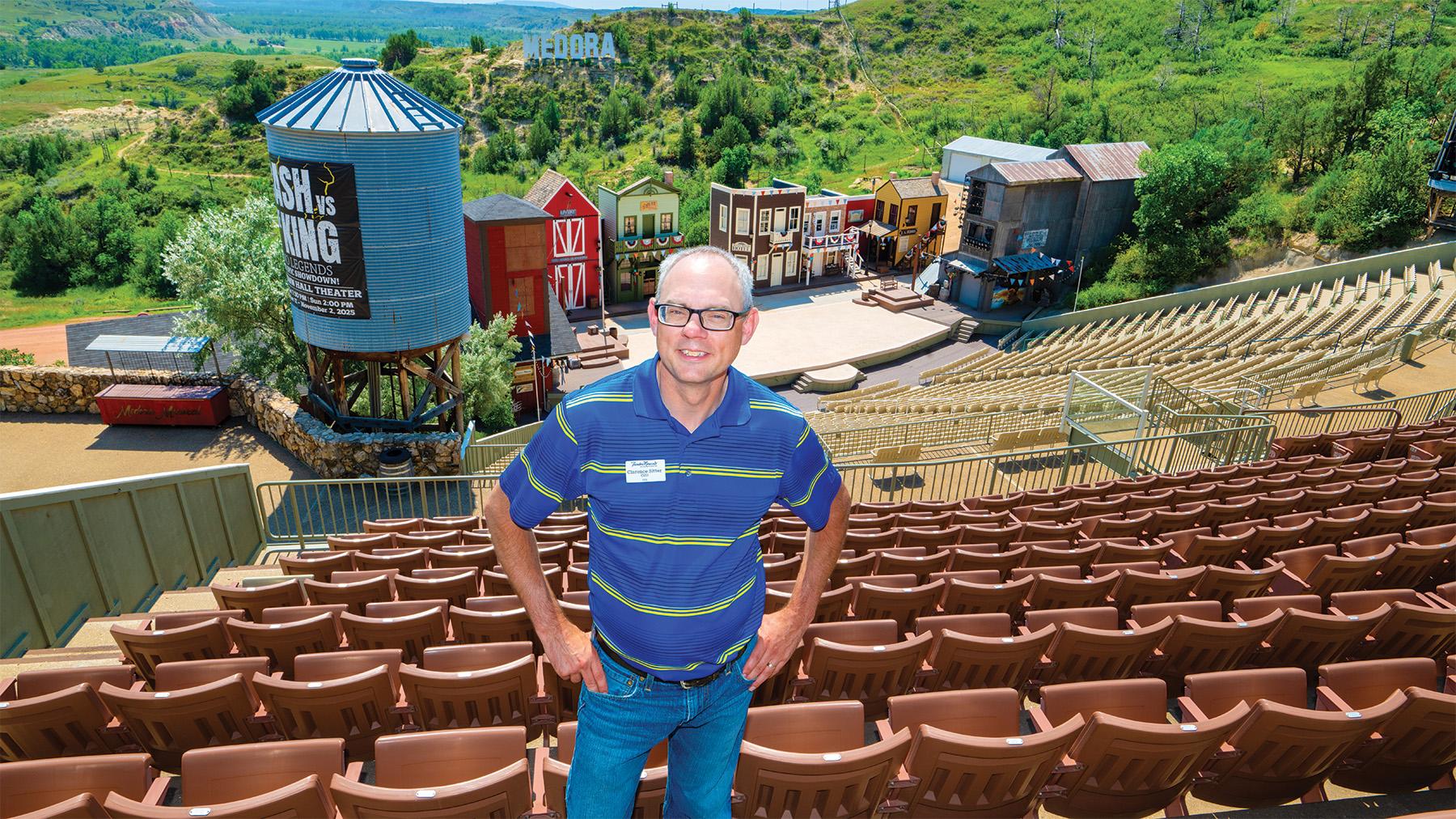 Clarence Sitter in from of the Medora musical sign